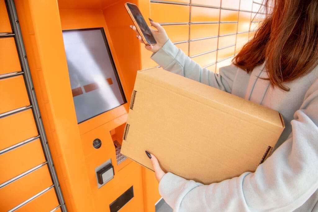 Resident retrieving a parcel from a package locker system, showing the limitations of lockers compared to solutions that automate package management in multifamily buildings